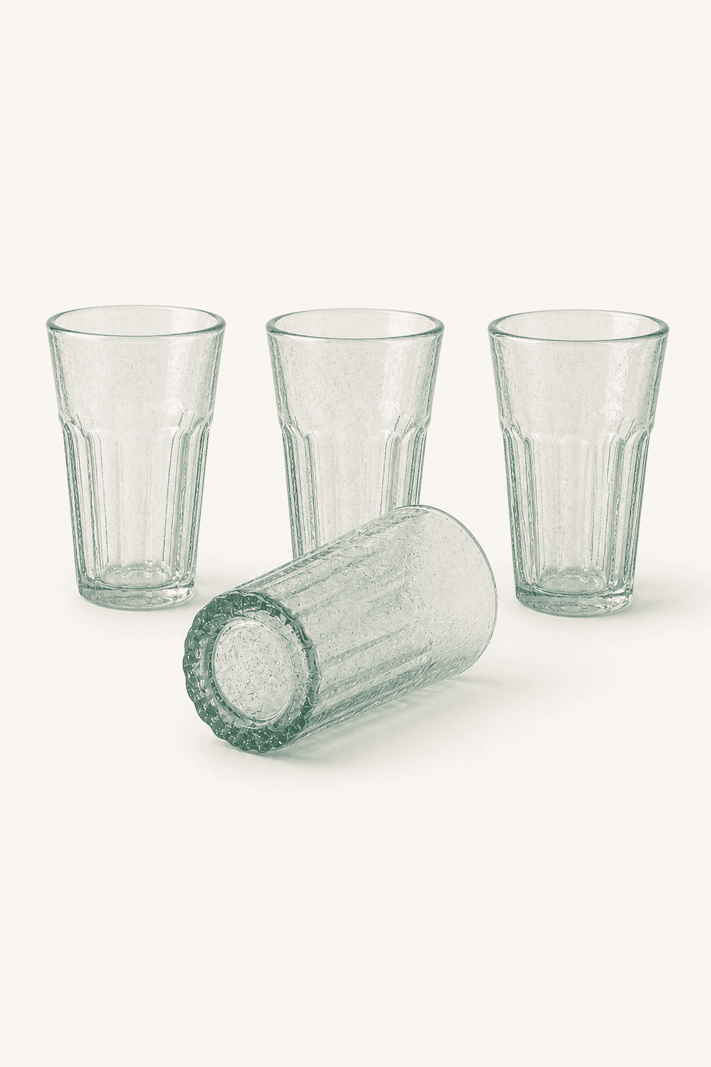 Four handmade Bia Hơi glasses arranged on a warm off-white background